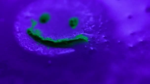 Tablet with green neon smile dissolves in water macro view — Stockvideo