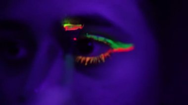 experienced artist applies green orange neon makeup macro