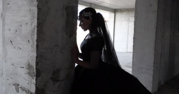 Paard vrouw in zwart jurk loopt handen op beton kolom — Stockvideo