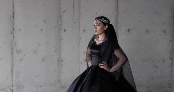 Professioneel model in lange zwarte jurk wandelingen aan de muur — Stockvideo