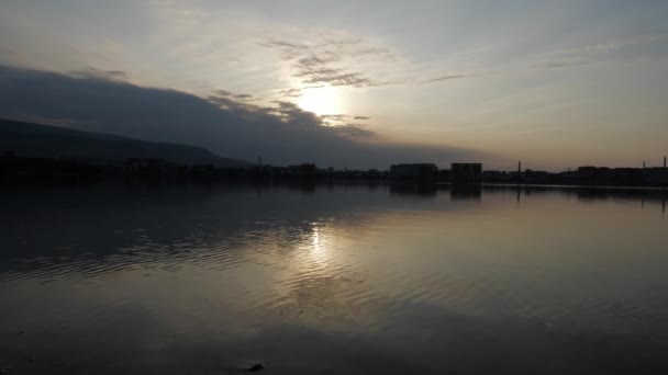 Calme l'eau du lac reflète les nuages lumineux de la lumière du soleil au coucher du soleil — Video