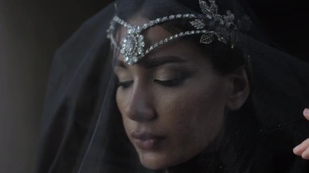 Lady looks straight from behind transparent veil closeup — Stock Video