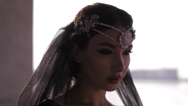 Model met tiara poses voor camera tegen wazig stadsbeeld — Stockvideo