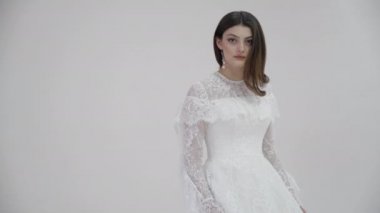 Gümüş küpeli beyaz gelinlik içinde çekici bir gelin.