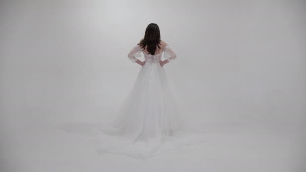 Bela morena em vestido de noiva branco longo com trem — Vídeo de Stock