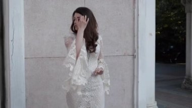 Gelinlik giymiş, dantelli kollu, uzun saçlı gelin.