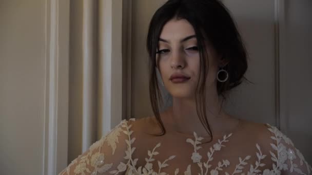 Брюнетка в білій відкритій плечовій сукні з дрібним вирізом — стокове відео