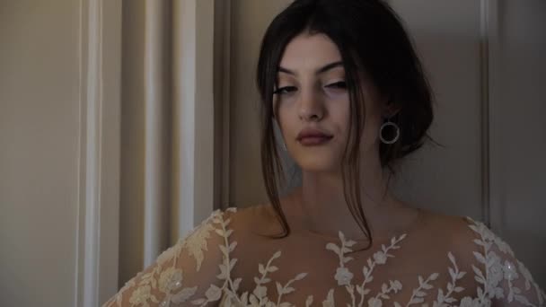 Bruna in abito bianco a spalla aperta con scollatura in pizzo — Video Stock