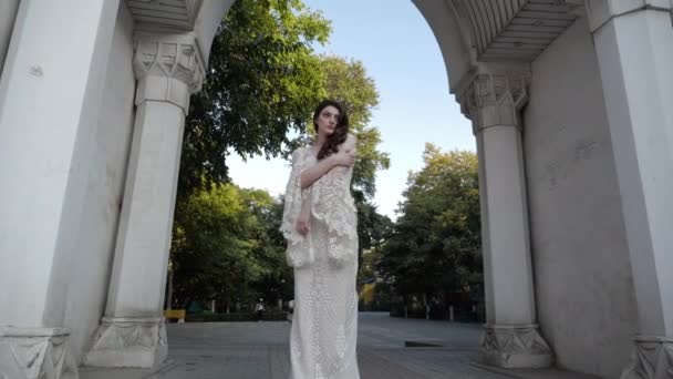Pretty brunette in long wedding dress with lacy cafe sleeves — Stock Video
