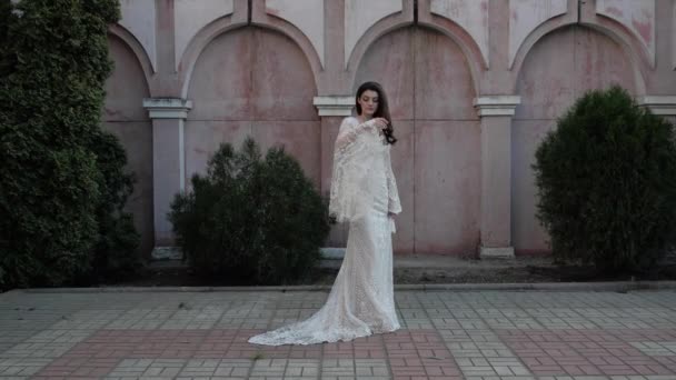 Model in lange strakke lacy trouwjurk poses voor camera — Stockvideo