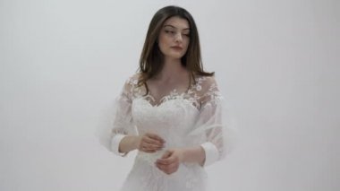 Temiz kollu beyaz gelinlik içinde profesyonel bir model.