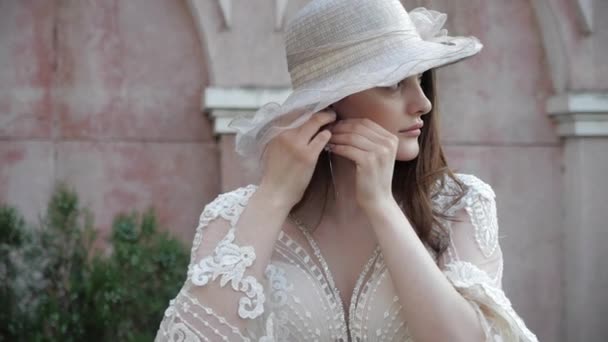 Elegante signora in cappello bianco e vestito indossa orecchino d'argento — Video Stock