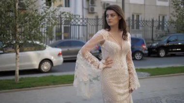 Kız şehirde dantelli koluyla el ele poz veriyor.