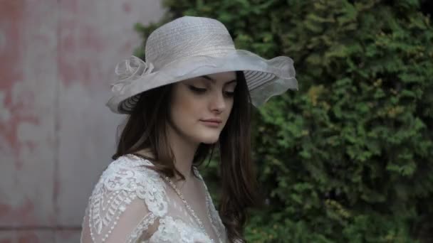 魅力的な花嫁は白い帽子にベルスリーブで手を動かす — ストック動画