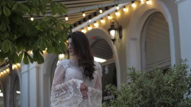 Леди в обтягивающем свадебном платье с длинными кружевными рукавами — стоковое видео