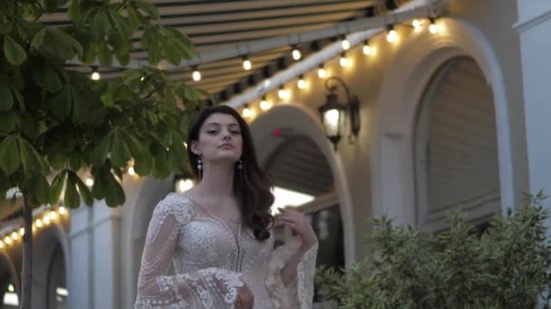 Hezká nevěsta fixuje dlouhé volné kudrnaté vlasy s rukou pózování — Stock video