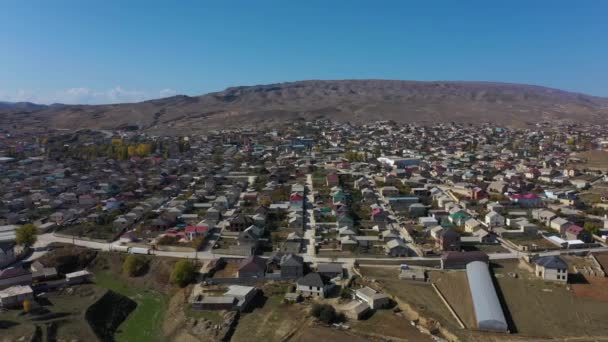 Casas de cidade perto de campos de repolho contra grande montanha — Vídeo de Stock