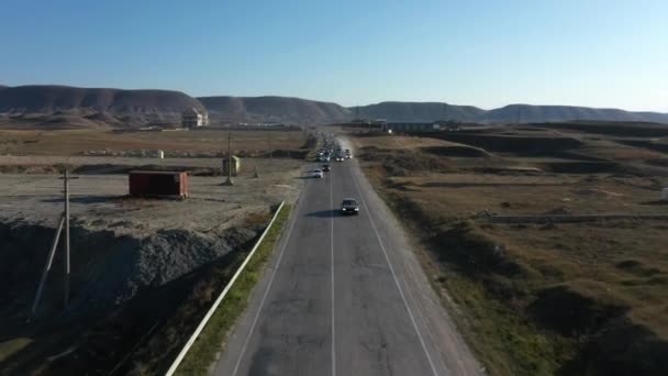 Nowoczesne samochody prędkości wzdłuż drogi asfaltowej przed doliną górską — Wideo stockowe