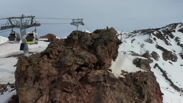 Pedra rochosa escura perto do teleférico da estância de esqui contra montanhas — Vídeo de Stock