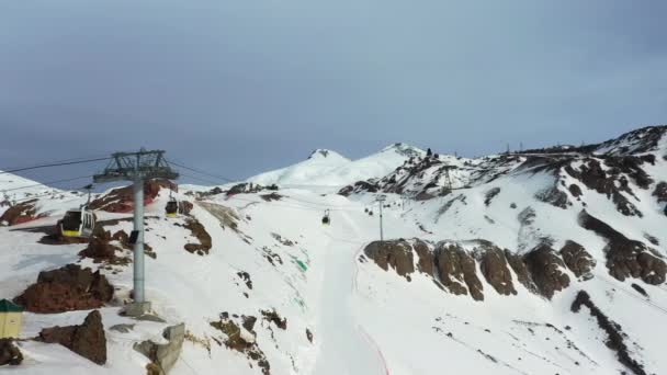 Χιονοδρομικό κέντρο καμπίνες με συρματόσχοινα κινούνται γρήγορα κατά χιονισμένα βουνά — Αρχείο Βίντεο