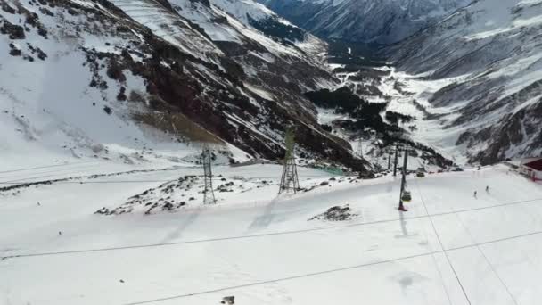 Esquiadores mover-se rapidamente ao longo de encostas íngremes entre montanhas nevadas — Vídeo de Stock