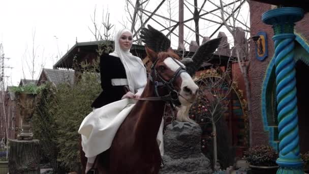 Žena v tradičním arabském kostýmu pózuje na kaštanovém koni — Stock video