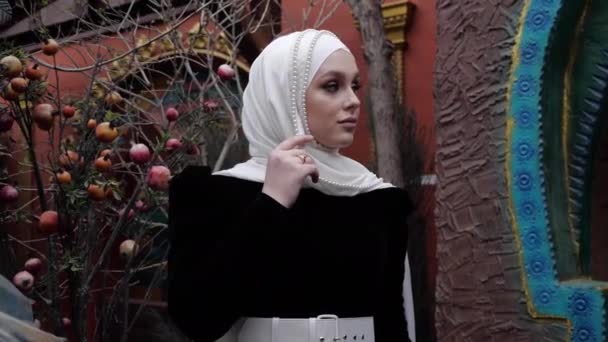 Девушка в традиционной арабской одежде рядом с гранатовым деревом — стоковое видео