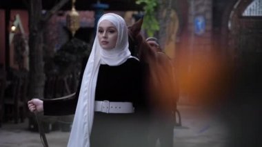 Arap elbiseli bayan ve başörtüsü kestane atına öncülük ediyor.