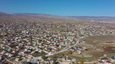 Büyük kayalık dağları ve küçük evleri olan dağlık arazi
