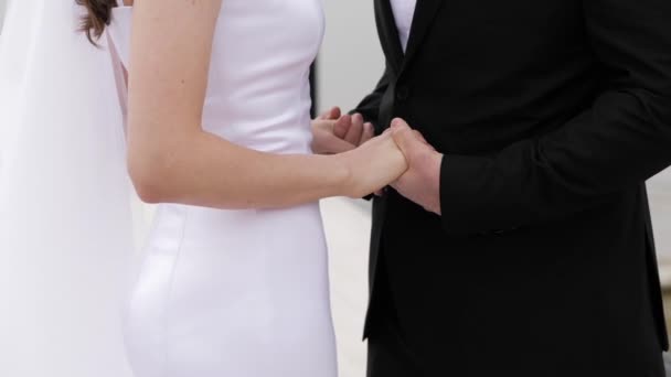 Vőlegény kéz fogja fiatal nő fehér szűk esküvői ruha — Stock videók