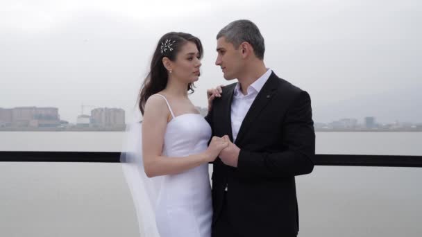 Romantický pár novomanželů se spojí za ruce a nakloní hlavy — Stock video