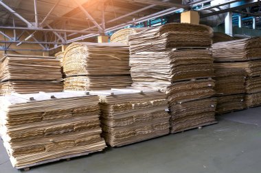 Üretim alanındaki sanayi deposunun bulanık parçasına karşı istiflenmiş kontrplak ve ahşap tahta ürünler. Uzayı kopyala Seçici odak.