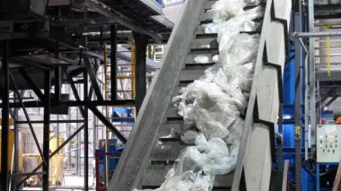 Modern atık geri dönüşüm tesisinde taşıyıcı taşınıyor. Çöp toplama ve ayıklama. Daha fazla atık için geri dönüşüm ve depolama.