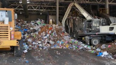 Grodno, Belarus - Ekim 2019: Çöp işleme tesisi olarak atık ile çevre kirliliği sorununun çözümü - tasnif ve işlemler için taşıyıcı banta yüklenmeye hazırlanan büyük çöp yığını