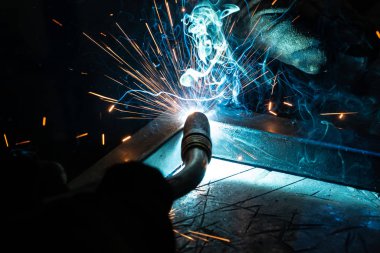 Kaynakçı çerçeveyi pişirir. Kaynakçı metali pişirir. Kaynakçı metal yapılar pişiriyor. Kaynak işe yarıyor. Kıvılcımlar, erimiş metal