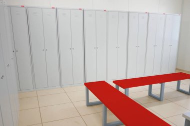 Dolaplı soyunma odası ve kırmızı bir bank.