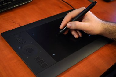 Tasarımcı bir grafik tabletine yakın plan çizer