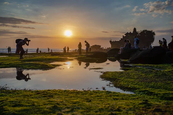 Los visitantes disfrutan de la puesta de sol en el templo de Tanah Lot, Bali, Indonesia —  Fotos de Stock