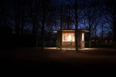 Sabahın erken saatlerinde bir bekçi kulübesinde, Tuileries kamu garında.