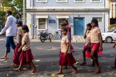 Pondicherry, Hindistan - 17 Mart 2018: Çıplak ayakla yürüyen okul çocukları arka planda sokak ismiyle kameranın önünden geçiyorlar