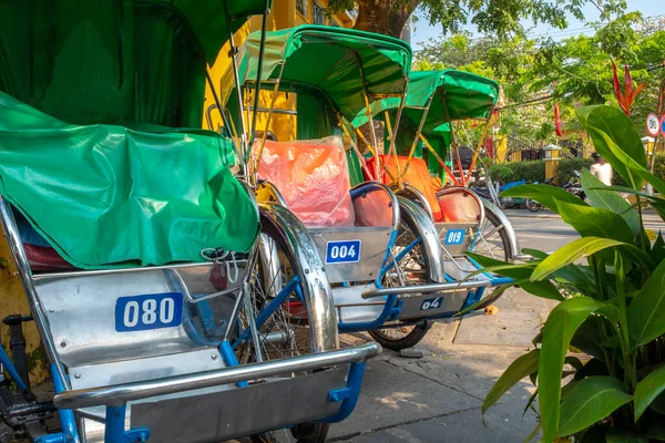 Gündüz vakti Hoi An, Vietnam 'da çekilen üç renkli çekçek müşteriyi bekliyor.