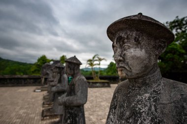 Hue, Vietnam - 16 Nisan 2018: İmparator Khai Dinh mezarlığındaki imparatorun danışmanlarının heykeli, insansız ve bulutlu bir gökyüzü