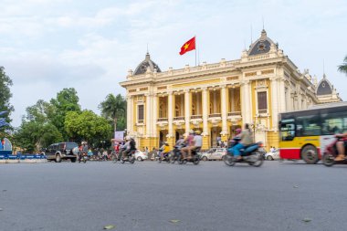 Hanoi, Vietnam - 30 Nisan 2018: Opera binası, cadde trafiği ve ön planda bir motosikletin geçişi