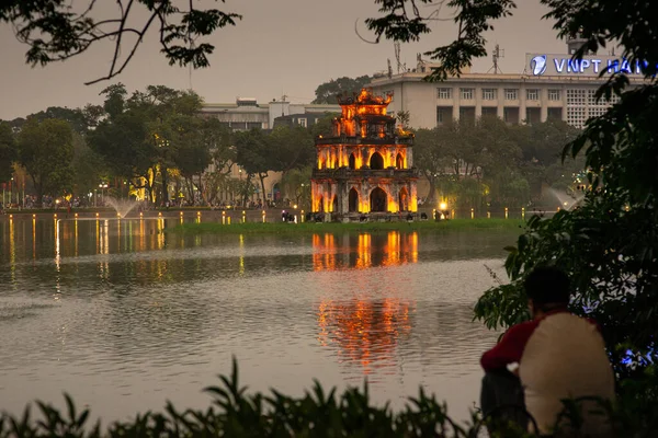 Tanımlanamayan adam, Hoan Kiem Gölü ve kaplumbağa kulesi, akşamüstü, Hanoi, Vietnam 'da çekildi.