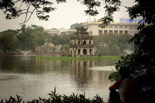 Tanınmayan adam, Hoan Kiem Gölü ve kaplumbağa kulesi, alacakaranlıkta, Hanoi, Vietnam 'da çekildi.