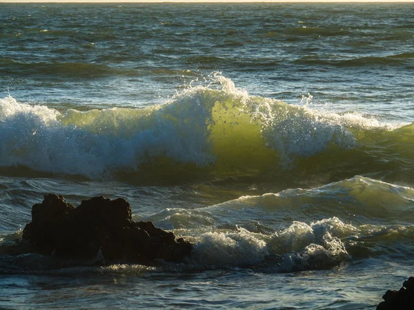 Vågorna är belyst av solnedgången — Stockfoto