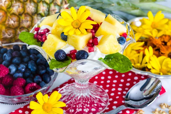 Ontbijt met muesli, yoghurt, fruit en eetbare bloemen — Stockfoto