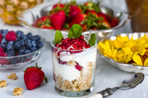 Завтрак с мюсли, йогуртом, фруктами и съедобными цветами — стоковое фото