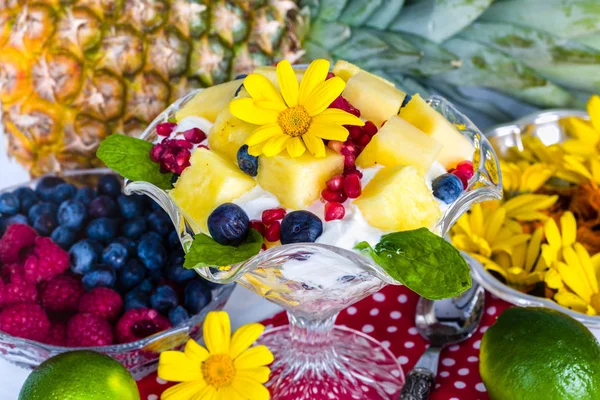 Ontbijt met muesli, yoghurt, fruit en eetbare bloemen — Stockfoto