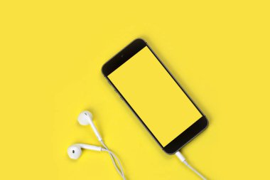 Frezya sarı arka planda akıllı telefon ve kulaklık